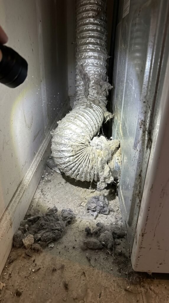 Old clogged dryer vent hose covered in lint